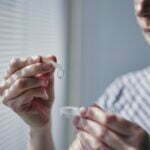 Young man opening contact lens case