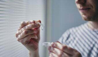 Young man opening contact lens case