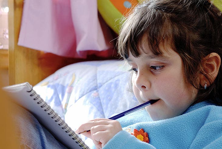 A child with a pen in his mouth