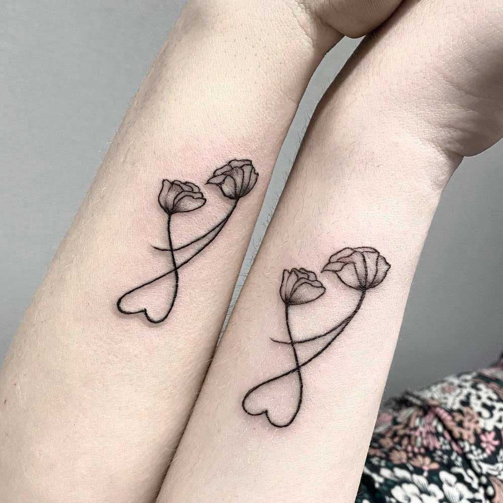 Two similar tattoos depicting two flowers intermingling to form a heart Two similar tattoos depicting two flowers intermingling to form a heart